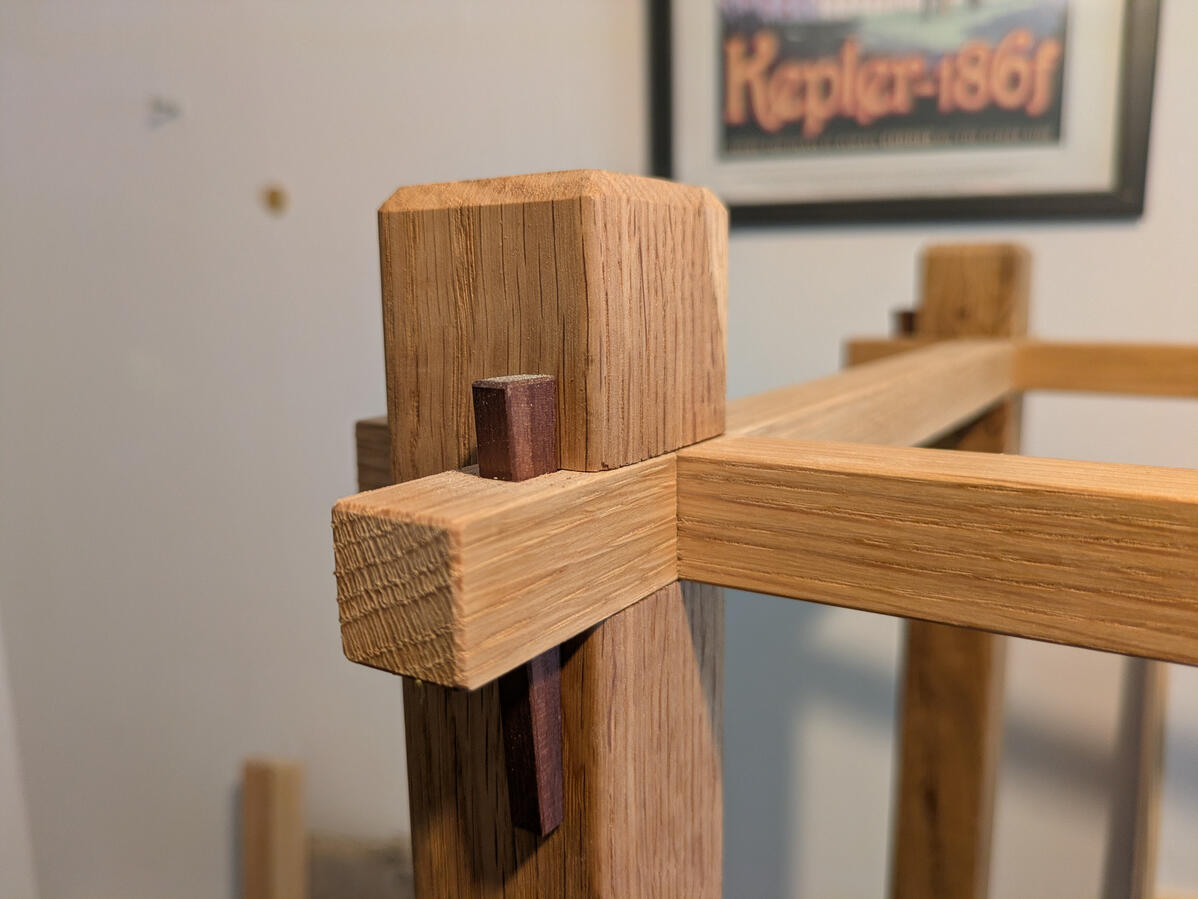 Leimfreie Eckverbindung aus Eiche, gesichert mit einem dunklen Holzkeil Leimfreie Eckverbindung aus Eiche, gesichert mit einem dunklen Holzkeil